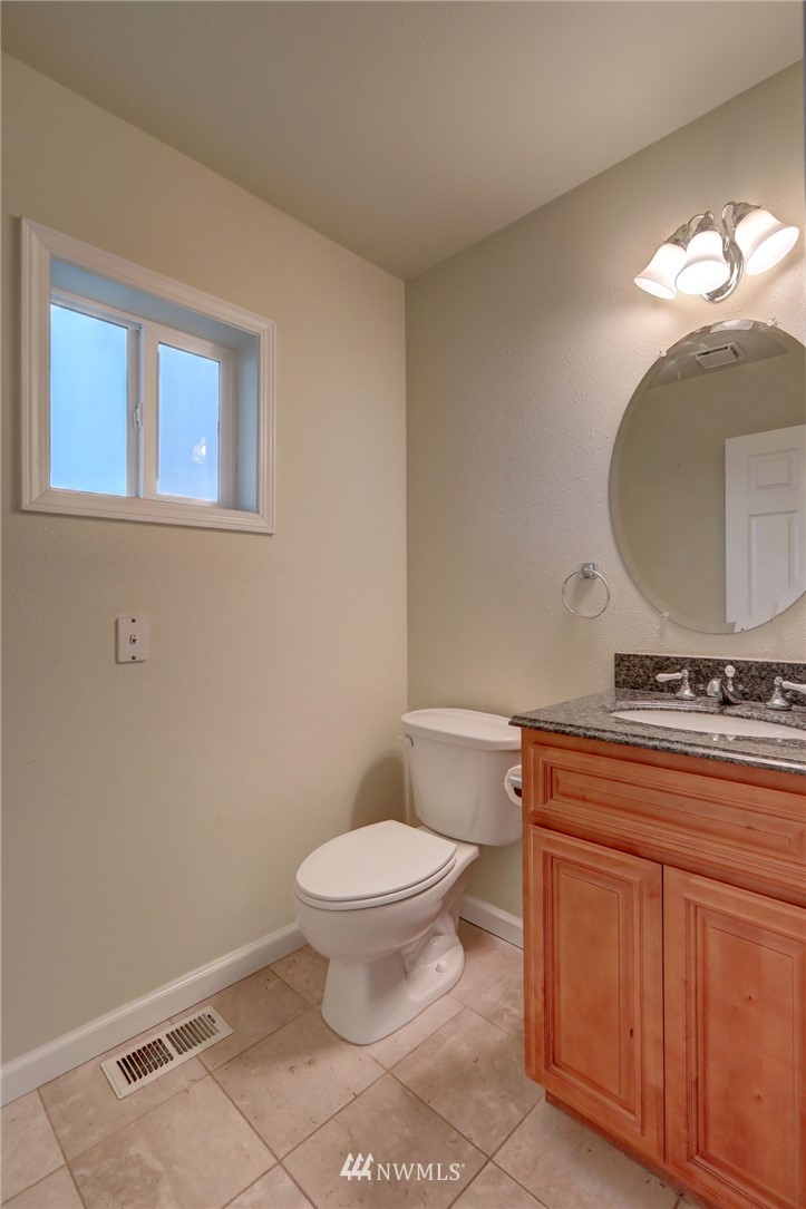 406 Stevens Avenue Northwest Renton, WA 98057 - Photo 8 of 24 a bathroom with a toilet a sink and mirror
