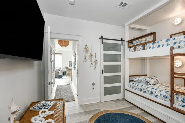 a view of a bedroom with wooden floor and windows