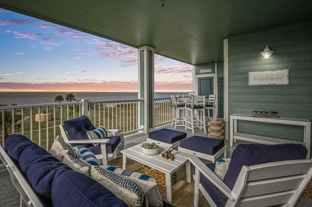 a view of a balcony with furniture and floor to ceiling window
