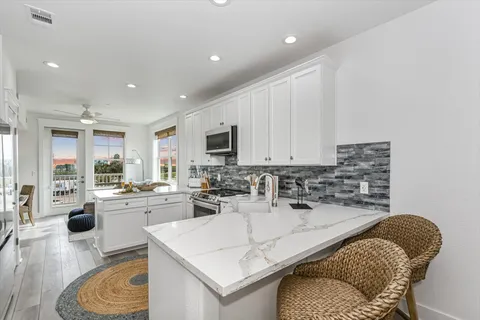 a kitchen with stainless steel appliances granite countertop a sink a stove and cabinets