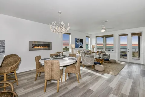 a view of a dining room with furniture a chandelier and wooden floor