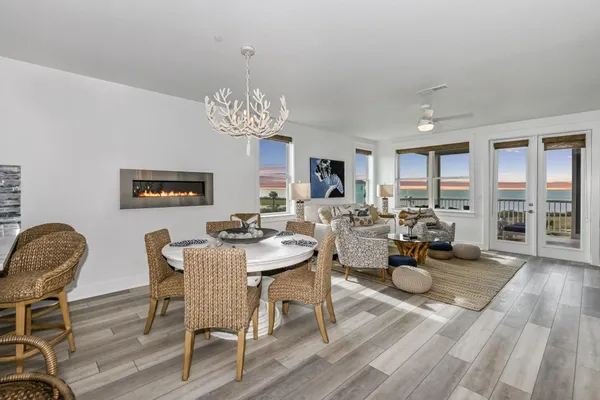 a view of a dining room with furniture a chandelier and wooden floor
