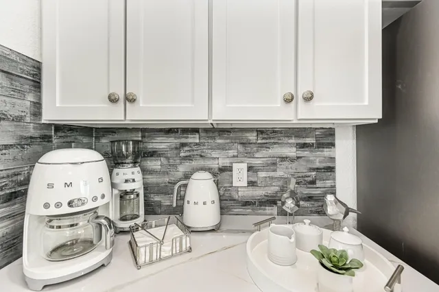 a kitchen with a sink a stove and white cabinets