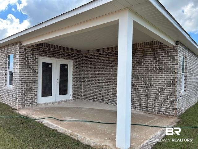 18127 Kent Circle Foley, AL 36535 - Photo 7 of 8 Property entrance featuring brick siding, a patio area, and french doors