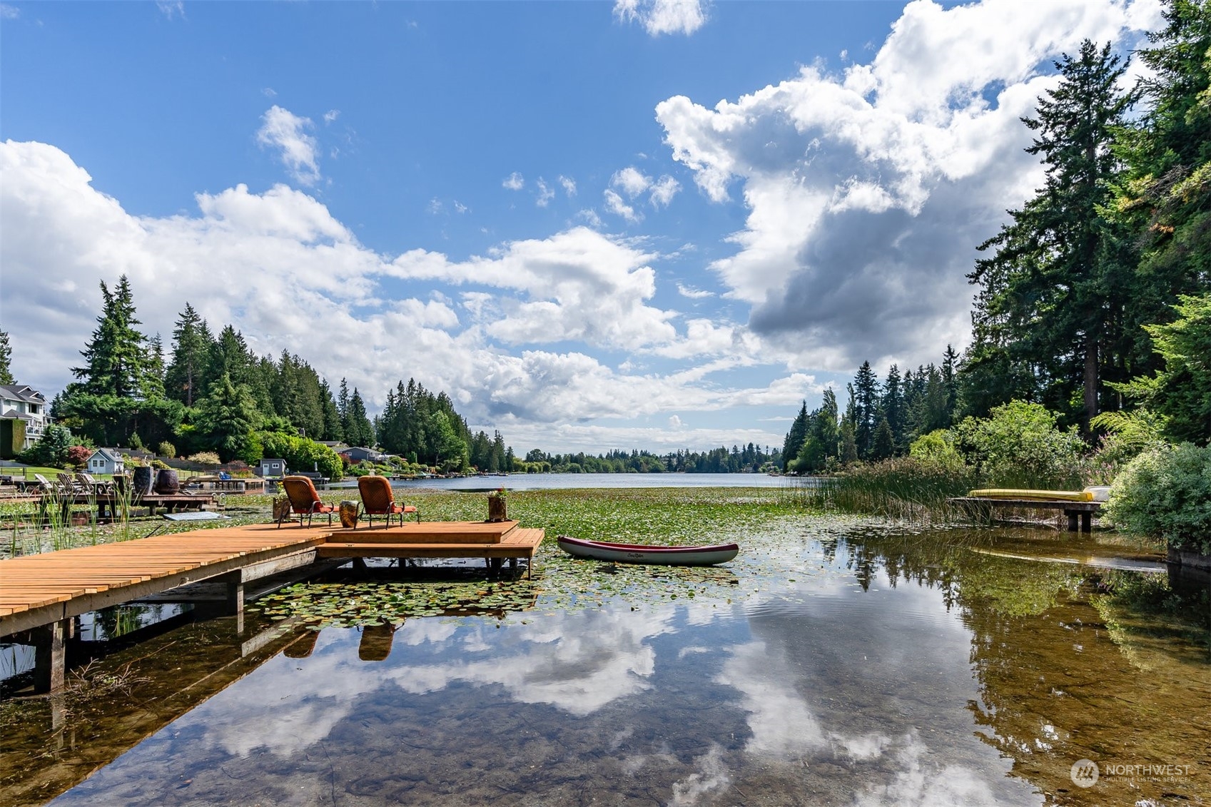 a view of a lake with lawn chairs