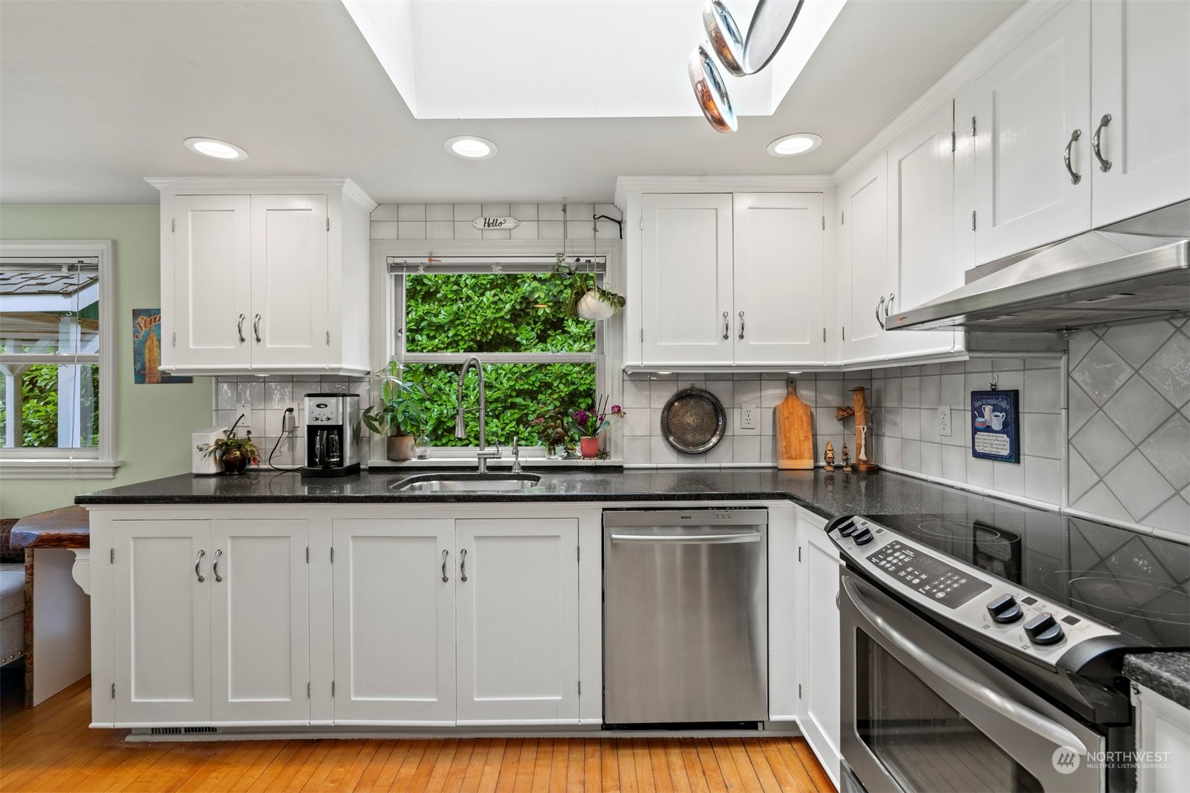 426 Lakeview Road Lynnwood, WA 98087 - Photo 13 of 33 a kitchen with granite countertop a stove a sink dishwasher and cabinets with wooden floor