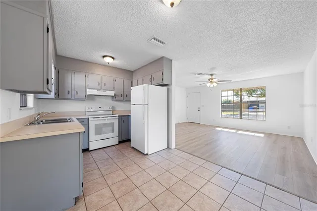 a kitchen with a sink a refrigerator and window