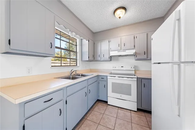 a kitchen with white cabinets and white appliances