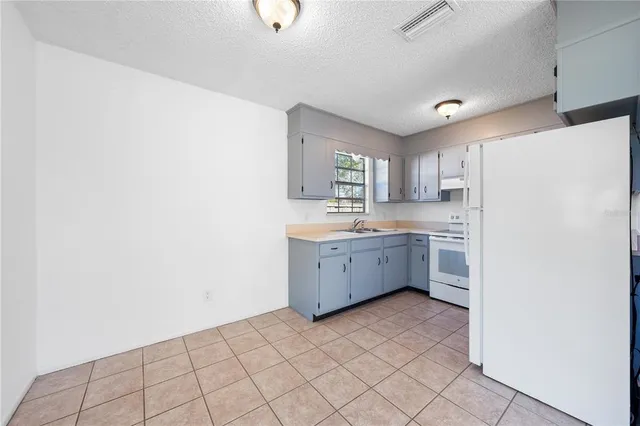 a kitchen with a cabinets a sink a window and stainless steel appliances