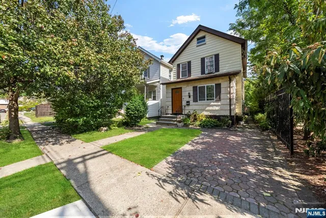 a front view of a house with a yard and trees