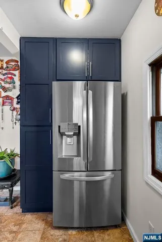 a metallic refrigerator freezer sitting in a kitchen