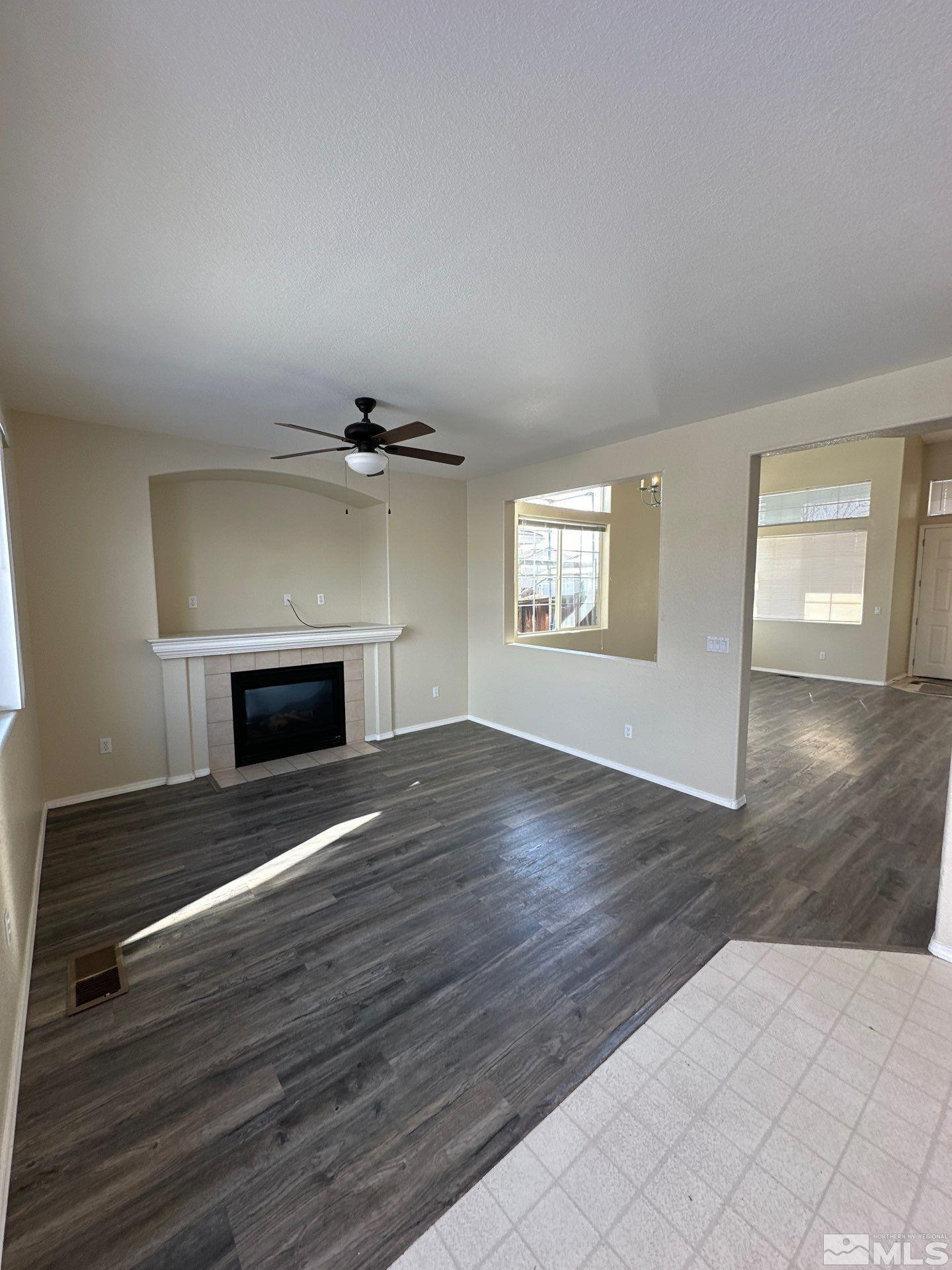 9648 Thunder Mountain Way Reno, NV 89521 - Photo 5 of 27 an empty room with wooden floor fireplace and windows