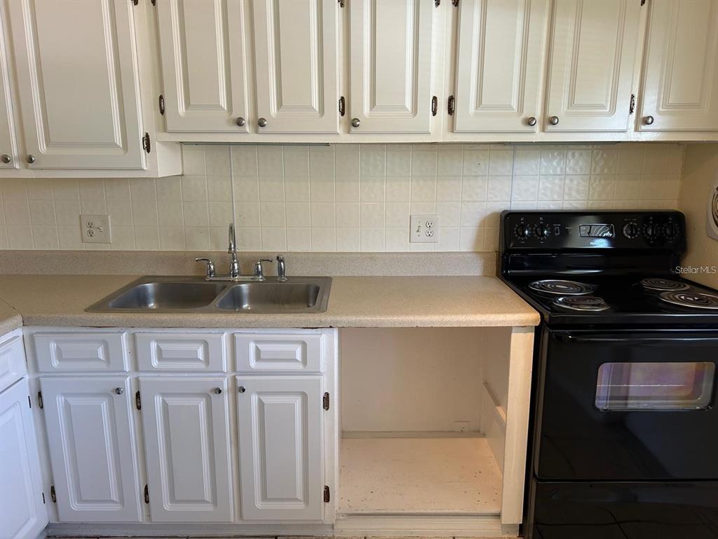 1627 West Oak Ridge Road, Unit D Orlando, FL 32809 - Photo 8 of 17 a kitchen with white cabinets and a sink