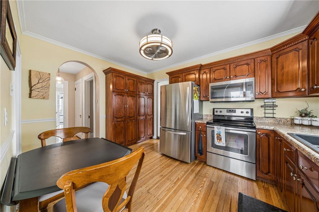 111 Orchard Avenue Rostraver Township, PA 15012 - Photo 7 of 42 a kitchen with stainless steel appliances granite countertop a stove a refrigerator a oven a sink with island chairs and wooden cabinets