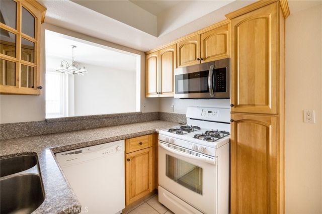 a kitchen with granite countertop a stove top oven microwave and cabinets