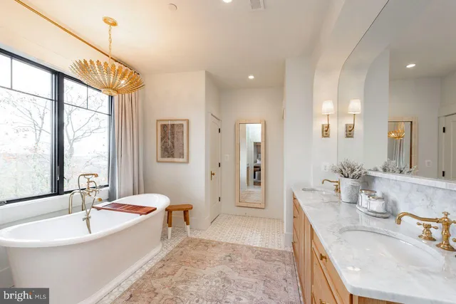 a spacious bathroom with a tub sink and mirror