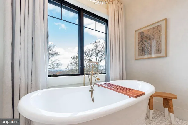 a white bath tub sitting in a bathroom next to a window