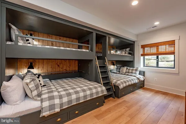 a kitchen with stainless steel appliances granite countertop a stove top oven a sink a dining table and chairs with wooden floor