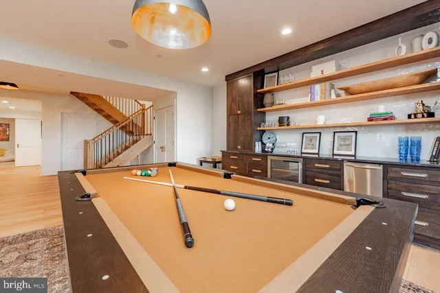 a living room with furniture a table and a pool table