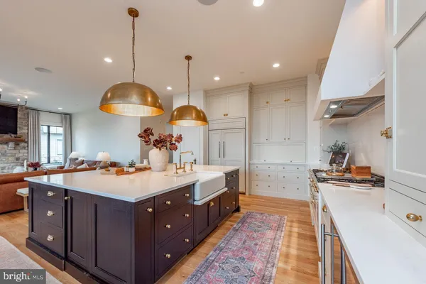 a large kitchen with kitchen island a stove a sink a center island and couches