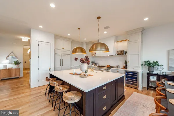 a kitchen with a sink a stove a refrigerator and chairs