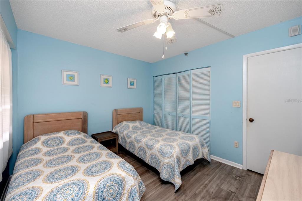 13720 Gulf Boulevard, Unit 503 Madeira Beach, FL 33708 - Photo 7 of 12 a bedroom with two beds and painted walls
