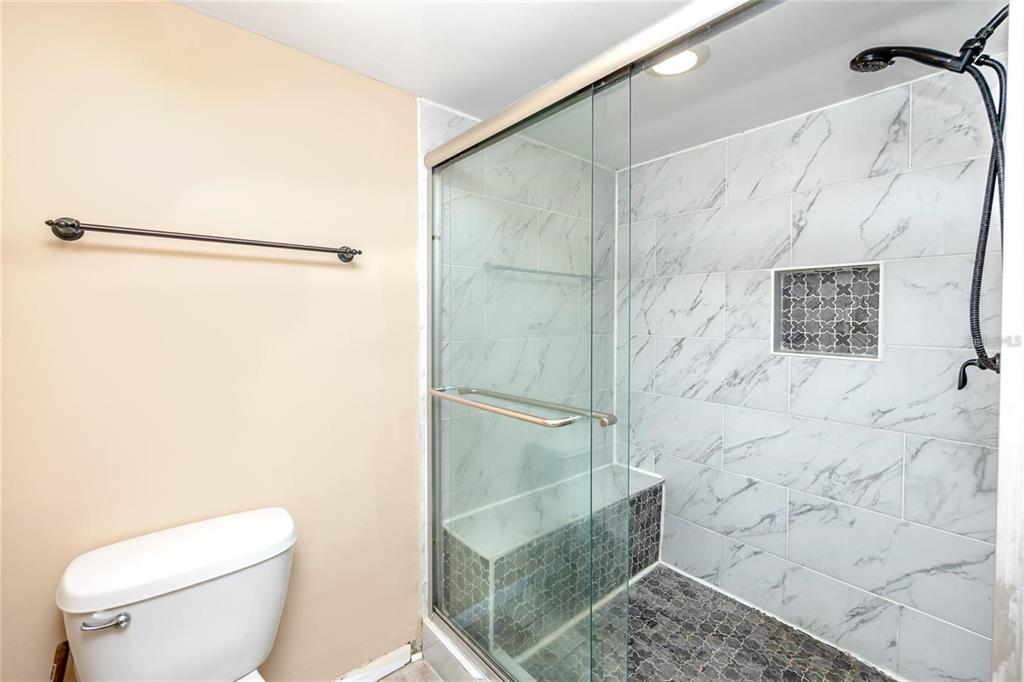 13720 Gulf Boulevard, Unit 503 Madeira Beach, FL 33708 - Photo 8 of 12 a bathroom with a shower and a toilet