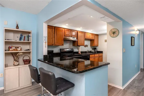 a kitchen with stainless steel appliances granite countertop a sink a stove and a refrigerator