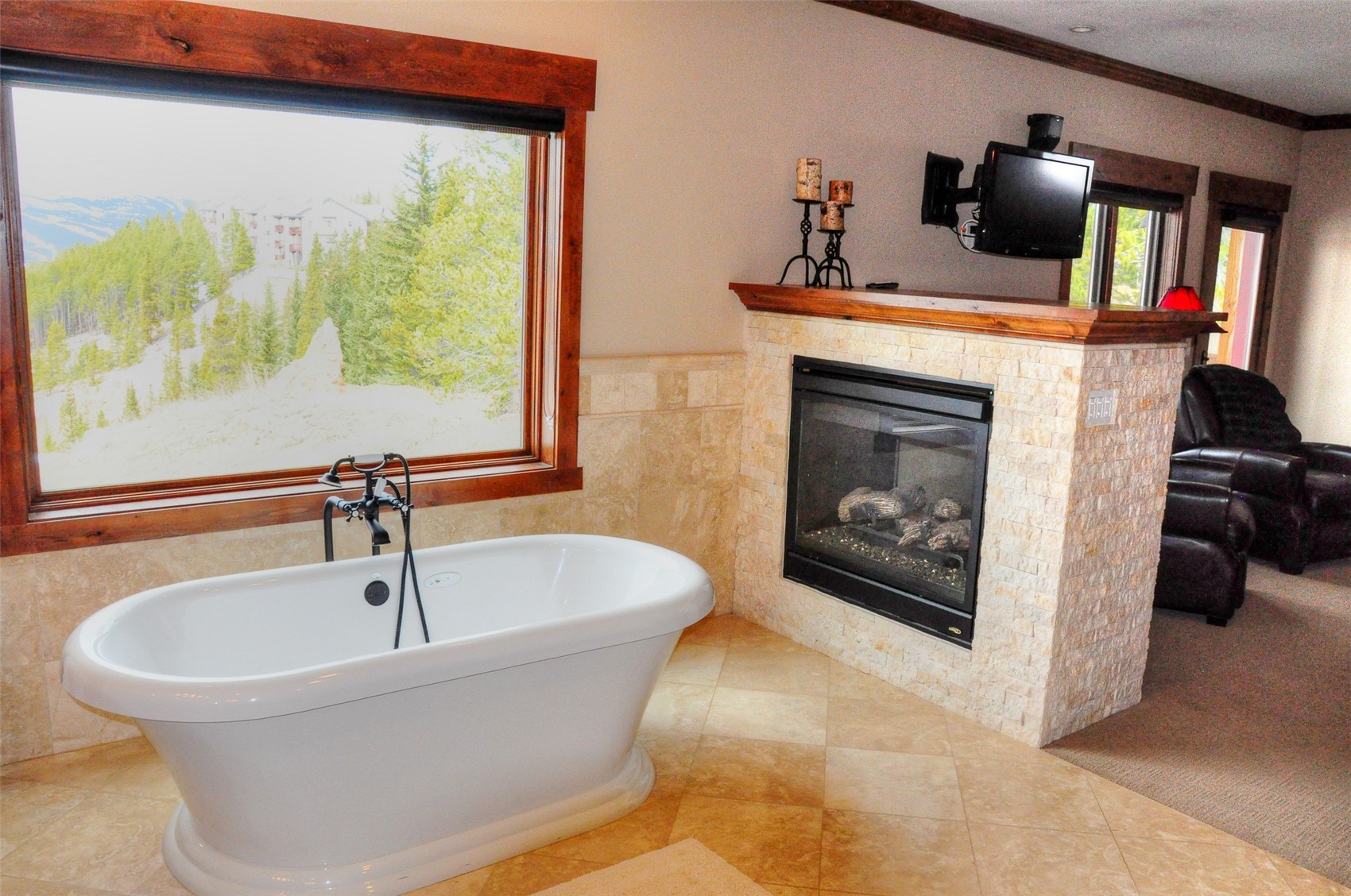 59 Club House Road, Unit C Breckenridge, CO 80424 - Photo 38 of 50 Full bath featuring a tiled fireplace, tile walls, a freestanding bath, wainscoting, and ornamental molding