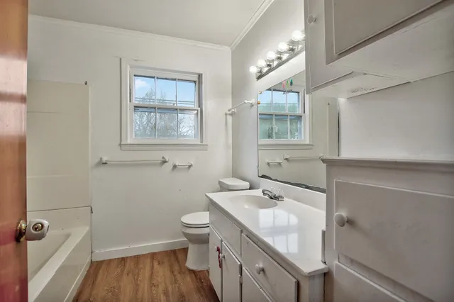 a bathroom with a granite countertop sink toilet and shower