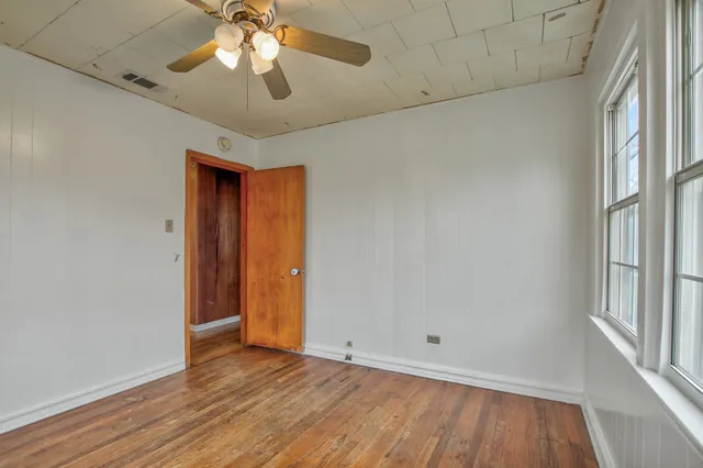 wooden floor in an empty room with a window
