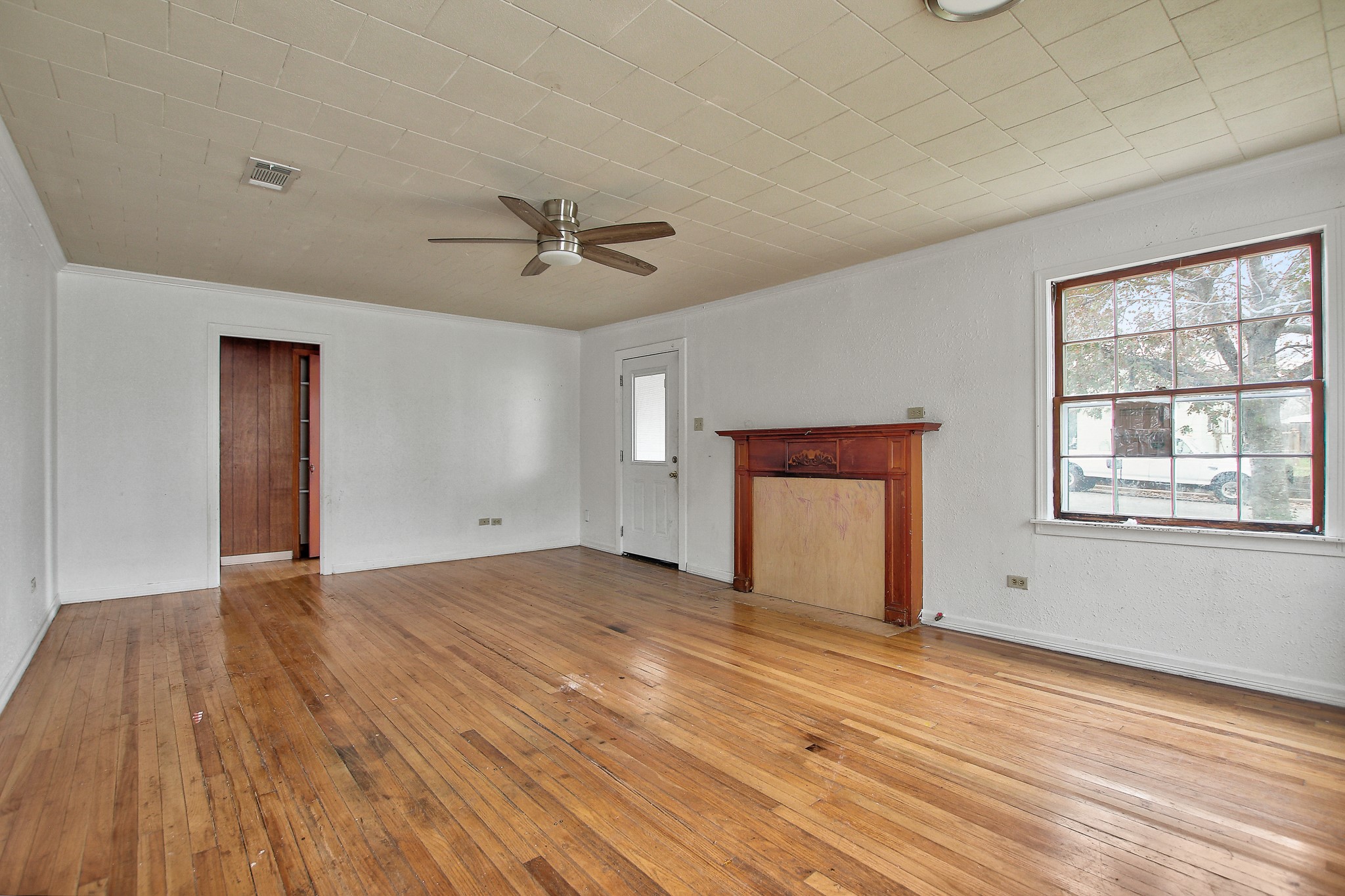 921 West 5th Street Taylor, TX 76574 - Photo 2 of 29 a view of an empty room with a window and wooden floor