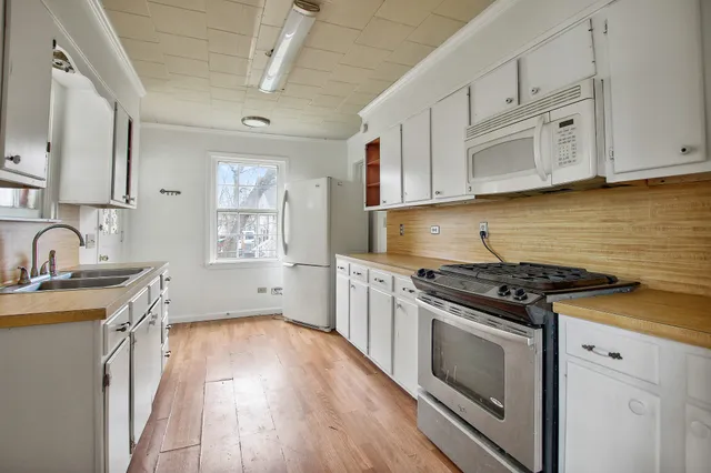 a kitchen with granite countertop wooden floors and stainless steel appliances