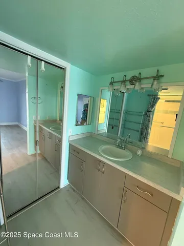 a bathroom with a granite countertop sink a mirror and a shower