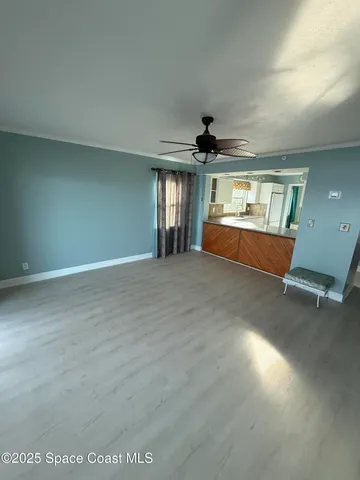 an empty room with windows and ceiling fan