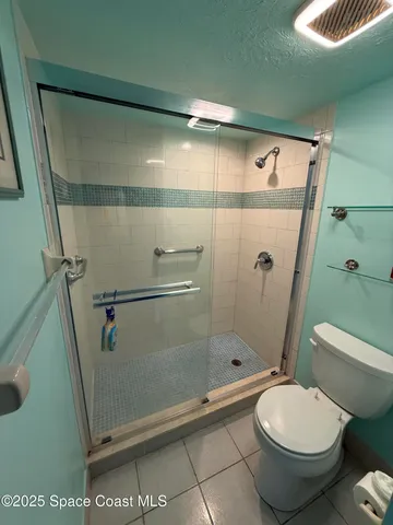 a bathroom with a toilet and a shower