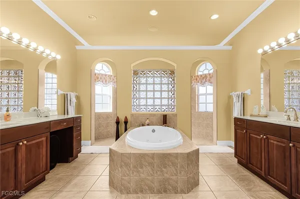 a spacious bathroom with a tub sink and mirror
