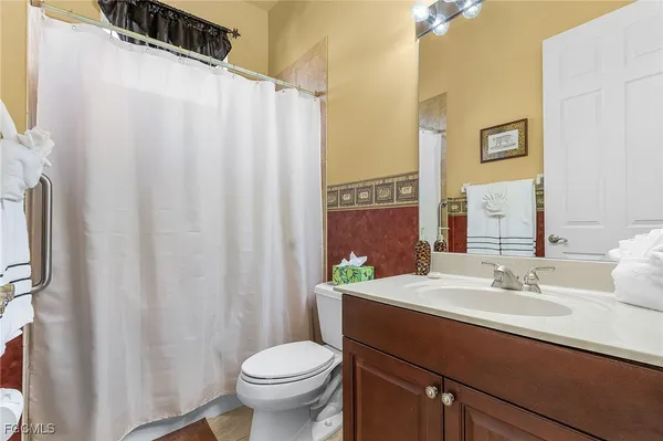 a bathroom with a sink a toilet and a mirror