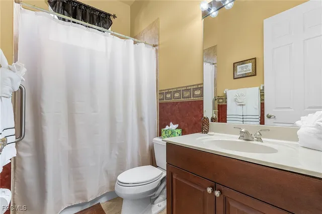 a bathroom with a sink a toilet and a mirror