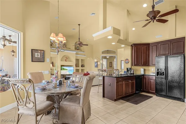 a kitchen with stainless steel appliances kitchen island granite countertop a table chairs and a refrigerator