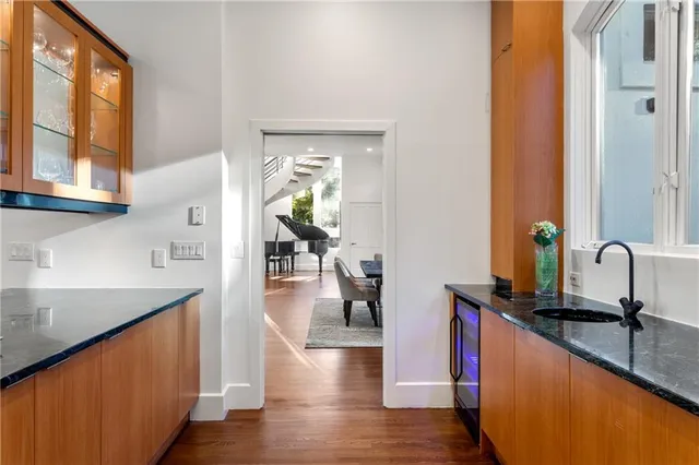 a kitchen with stainless steel appliances granite countertop wooden floor a sink and a large window