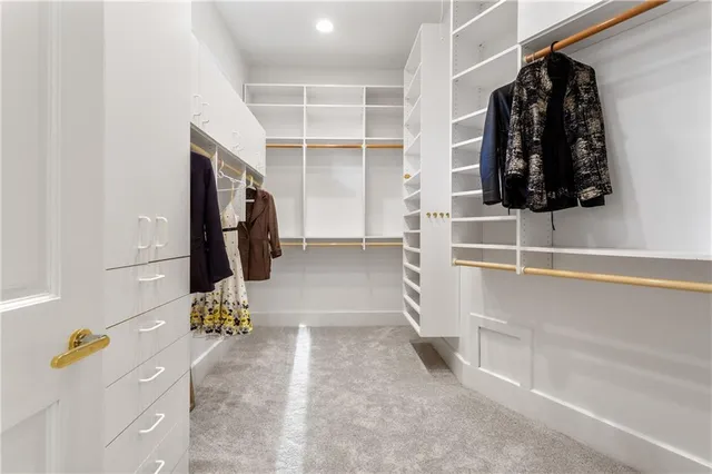 a view of walk in closet with clothes and shoes
