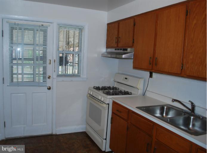 1126 Kevin Road Baltimore, MD 21229 - Photo 16 of 24 a kitchen with granite countertop a sink stove and cabinets