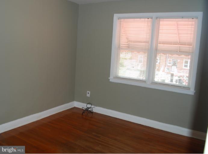 1126 Kevin Road Baltimore, MD 21229 - Photo 17 of 24 an empty room with wooden floor and windows