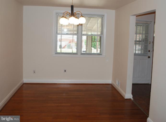 1126 Kevin Road Baltimore, MD 21229 - Photo 7 of 24 an empty room with wooden floor and windows