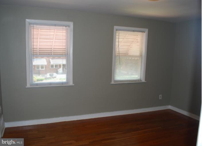 1126 Kevin Road Baltimore, MD 21229 - Photo 8 of 24 a view of an empty room with wooden floor and a window