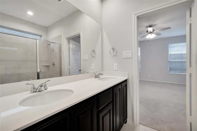 a bathroom with a double vanity sink a mirror and a shower