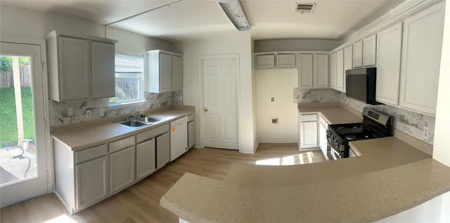 a kitchen with a sink appliances and cabinets