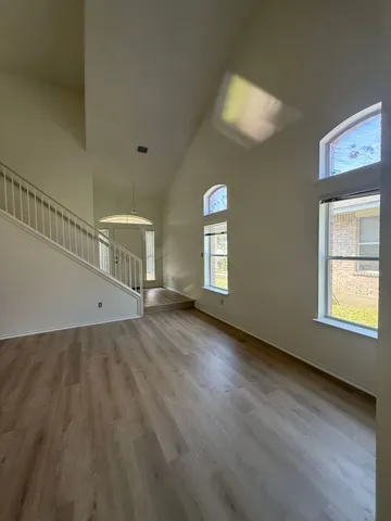 a view of a livingroom with wooden floor and window