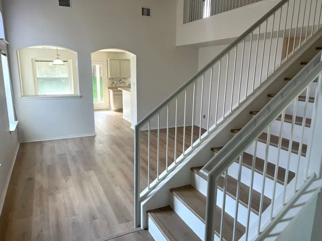 a view of staircase with wooden floor and white walls